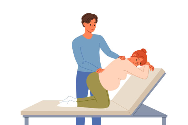 Man gives massage to pregnant woman kneeling on hospital bed waiting for labor to begin. Caring husband takes care of pregnant wife experiencing back pain while awaiting birth of child.